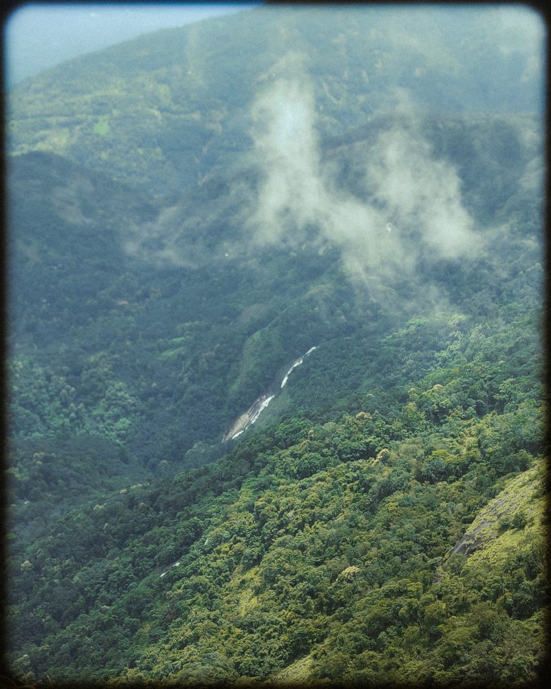 A winding waterway visible deep in a densely forested valley