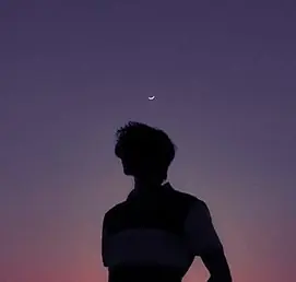 A person silhouetted under a crescent moon
