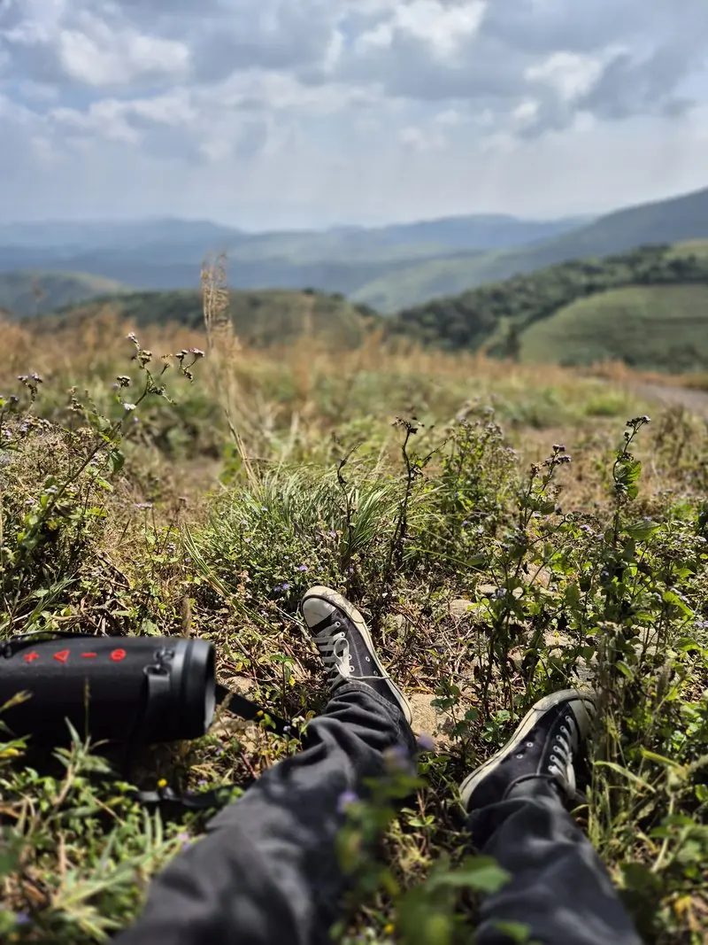 Boots resting above a valley of green hills
