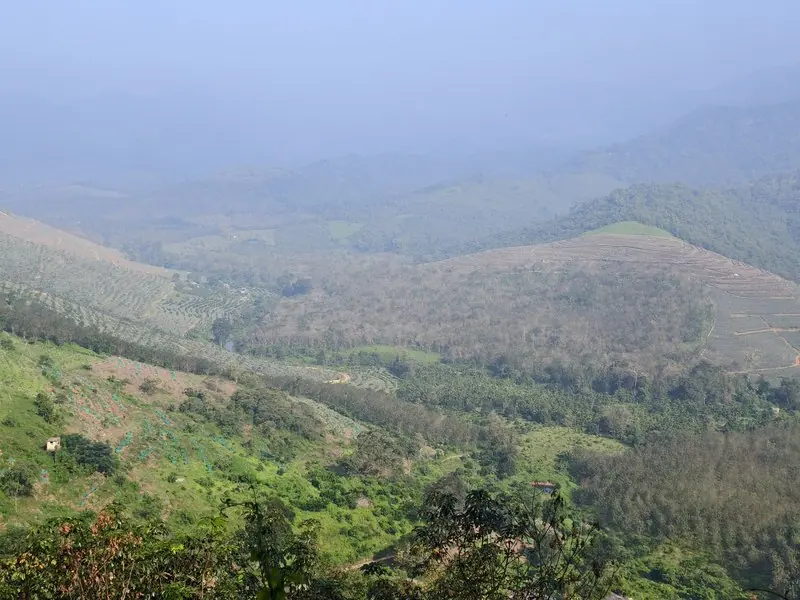Layered green hills fading into a hazy valley