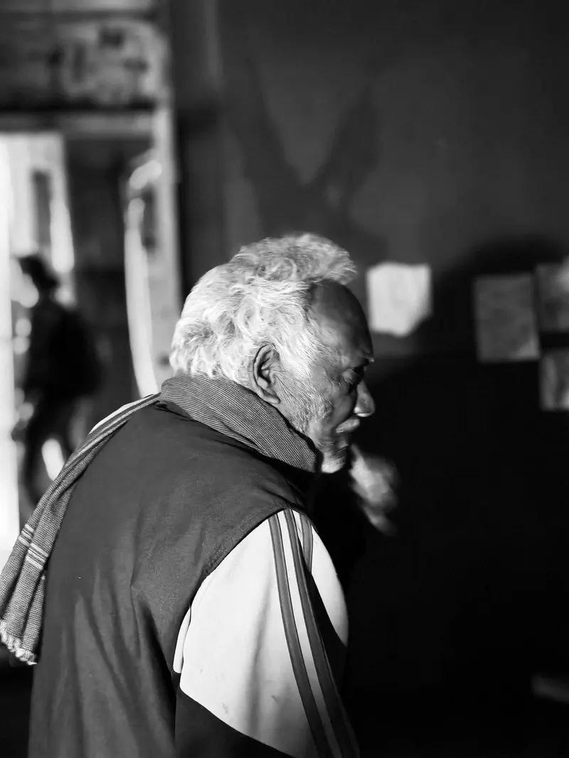 An older person in profile in a black and white photograph