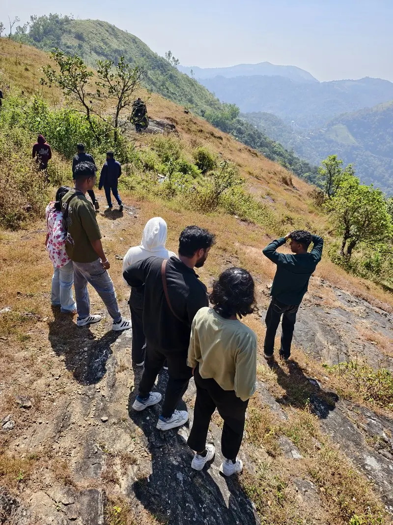 A group walking along a grassy hillside path