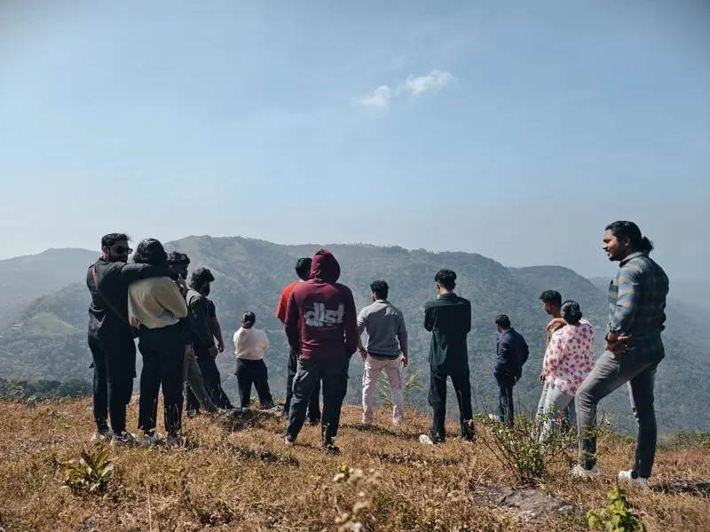 Friends gathered on a rocky ridge above distant hills