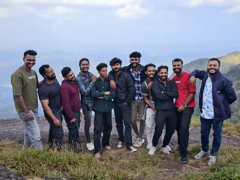 A group of friends posing together on a mountain ridge