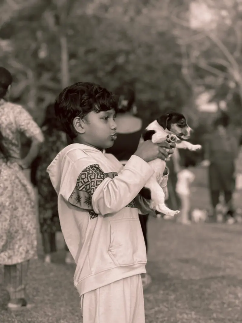 A child standing in a park in a black and white photograph