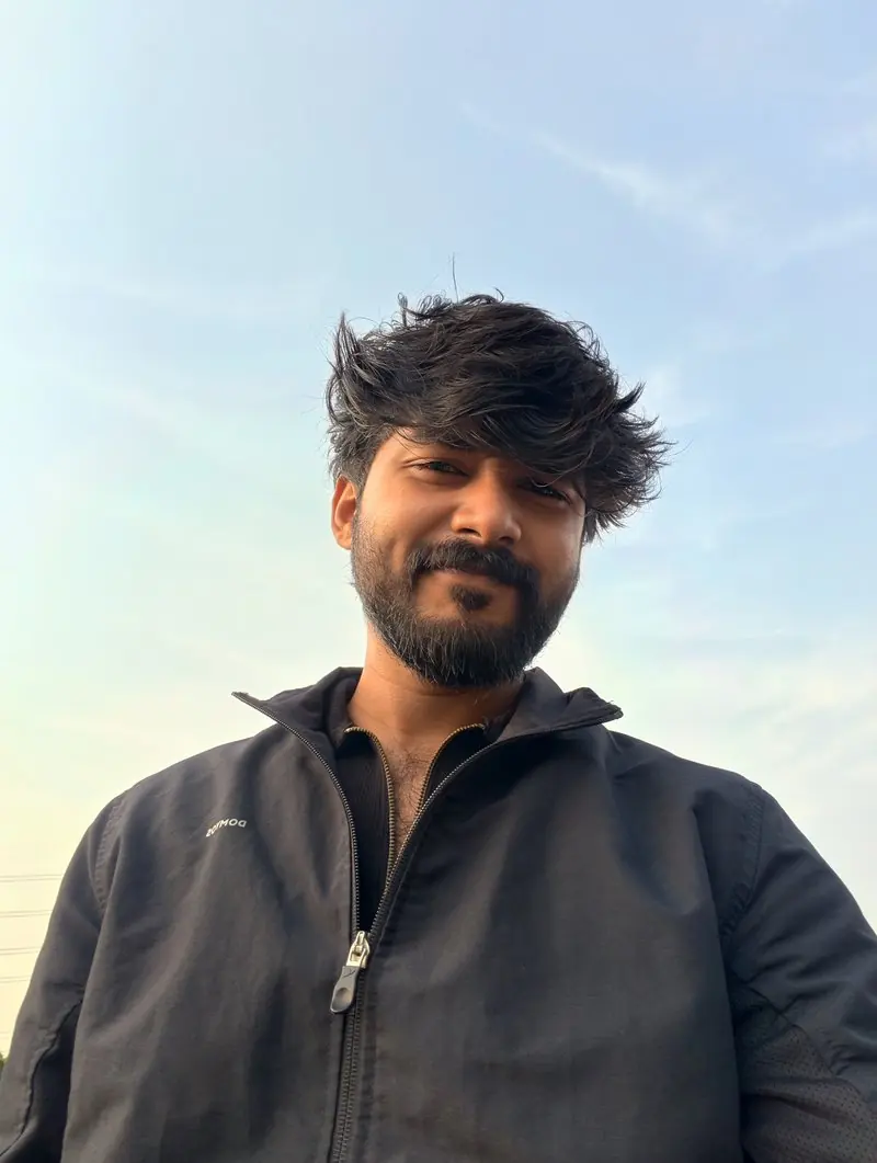 A portrait of a person outdoors beneath a blue sky