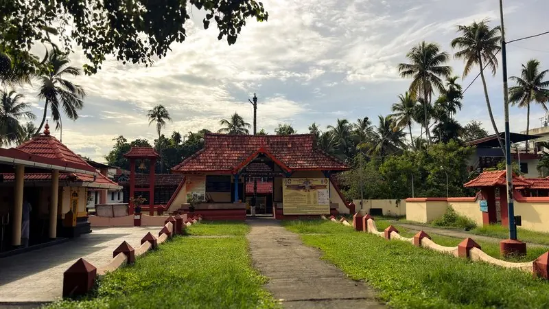A courtyard and tiled temple buildings framed by palm trees